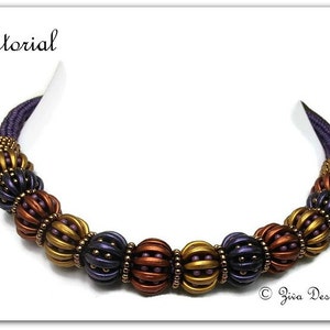 May include: A purple, copper and gold beaded necklace with a woven design. The necklace is made of small beads and has a rounded shape.