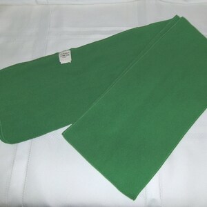 May include: A green fleece scarf folded in half. The scarf has a white tag with the text "Old Navy Fleece Neck Warmer" on it.