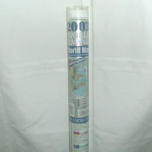 May include: A rolled-up, laminated 2003 World Almanac World Map. The map is encased in a clear plastic tube. The text on the tube includes the title, the year, and the word "laminated". The map itself is visible through the tube.
