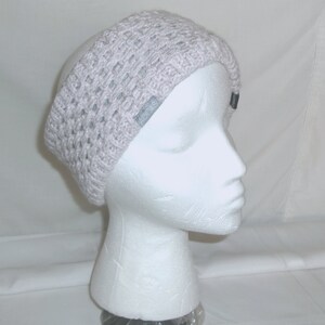 May include: A gray knitted headband with a white Adidas logo. The headband is on a white mannequin head.