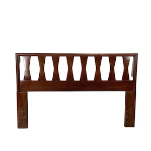 May include: A rectangular wooden headboard with a rich brown finish. The design features a solid horizontal base rail and a series of eight vertical slats, each shaped with a narrow center and wider ends, framed by a sturdy top border.