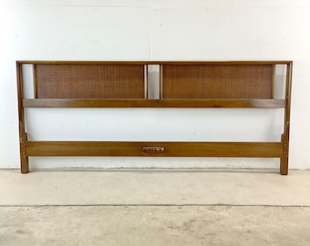 May include: A wooden headboard with a woven cane panel and a simple design. The headboard is brown and has a rectangular shape.
