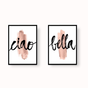 Può includere: Due stampe incorniciate con cornici nere e sfondi bianchi. Le stampe presentano le parole "ciao" e "bella" in scrittura nera su uno sfondo acquerellato rosa.
