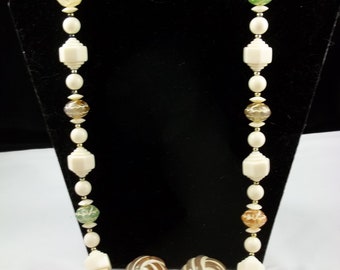 SALE     This vintage necklace has multiple size cream-colored beads with colorful accents.  Earrings are a peach color.