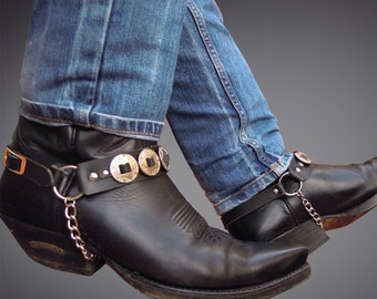 Zwarte leren laarzen, conchos-cowboykettingen, sporen van bikerlaarzen