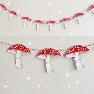 May include: A red and white mushroom garland with a string of red thread connecting the mushrooms. The mushrooms are paper cutouts with white stems and red and white tops.