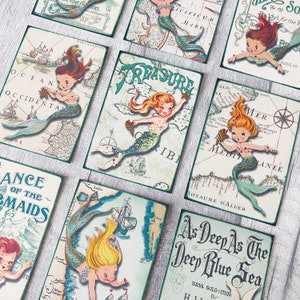 May include: A set of nine vintage-style cards featuring mermaids and nautical maps. Each card has a different mermaid design and a map background with text like "Treasure", "Ocean Occidental", and "As Deep As The Deep Blue Sea".