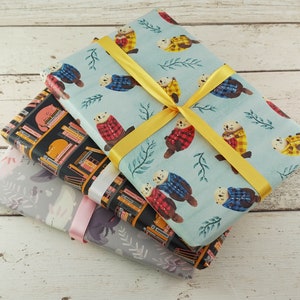 May include: Three wrapped gifts with patterned paper. One has a light blue background with otter illustrations wearing plaid shirts, tied with a yellow ribbon. Another has a black background with cat and book illustrations. The third has a gray background with floral illustrations.