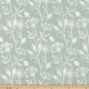 May include: A light green fabric with a white floral pattern. The pattern features small flowers and leaves.
