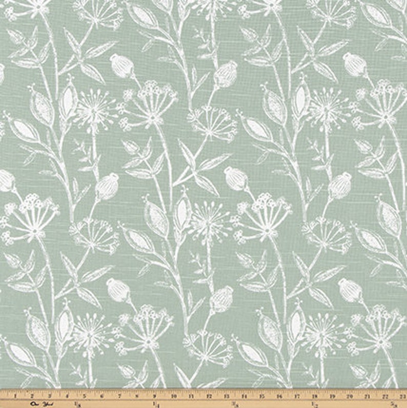 May include: A light green fabric with a white floral pattern. The pattern features small flowers and leaves.