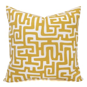 May include: Square decorative pillow with a mustard yellow and white geometric pattern. The pillow features a repeating maze-like design, creating a modern and stylish look. The pillow is a square shape, perfect for adding a pop of color and pattern to any room.