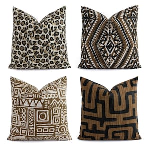 May include: Four decorative throw pillows with different geometric and animal print patterns. The pillows are brown, black, and white.