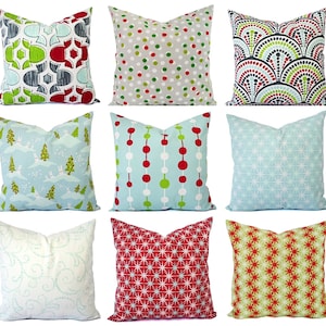 May include: Ten decorative throw pillows with various patterns. The pillows feature a variety of colors, including red, green, blue, and white. The patterns include polka dots, geometric shapes, and snowflakes.