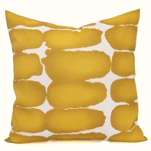 May include: Square decorative pillow with a mustard yellow and white abstract pattern. The pillow features a repeating design of large, irregular shapes in a warm yellow hue against a white background. The pillow is a square shape.