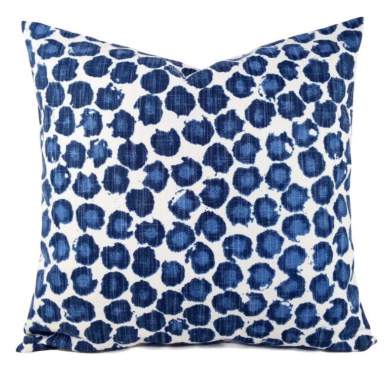 Puede incluir: Una almohada azul y blanca con un dise&ntilde;o abstracto azul y blanco. La almohada est&aacute; hecha de una tela suave y texturizada.