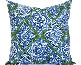 May include: Square decorative pillow with a geometric pattern. The pillow features a repeating design of blue and white diamond shapes set against a green background. The pattern includes floral and geometric elements.