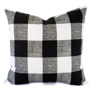 May include: Black and white buffalo check pillow cover. The pillow cover is made of a soft, textured fabric.