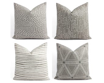 May include: Four decorative throw pillows with different geometric patterns in shades of gray and white.