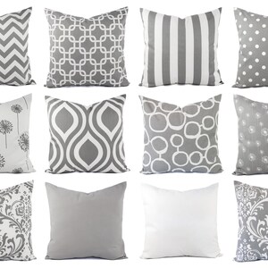 Pode incluir: Doze almofadas decorativas com v&aacute;rios padr&otilde;es geom&eacute;tricos e florais em tons de cinza e branco.