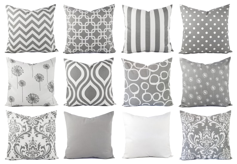 Pode incluir: Doze almofadas decorativas com v&aacute;rios padr&otilde;es geom&eacute;tricos e florais em tons de cinza e branco.