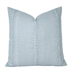 May include: A light blue throw pillow with a white speckled pattern.