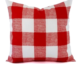 May include: A square decorative pillow with a bold red and white checkered pattern. The pillow has a classic gingham design, perfect for adding a touch of farmhouse style to any room. The pillow is made of a textured fabric.