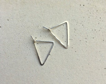 May include: A pair of silver triangle earrings. The earrings are simple and minimalist in design.