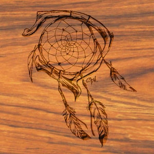 Peut inclure: Un attrape-rêves en bois brun avec une toile circulaire et des plumes qui pendent du bas. L'attrape-rêves est sculpté dans un morceau de bois avec les initiales "C.W." gravées dans le bois.