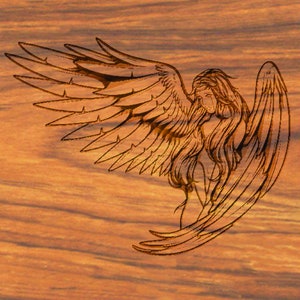 May include: A detailed line drawing of an angel with wings spread wide, carved into a wooden surface. The angel is depicted with long flowing hair and a sorrowful expression.