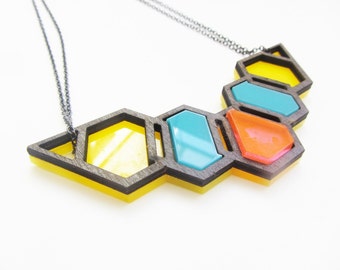 Geometric laser cut hive necklace in wood and acrylic.