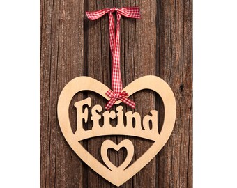 May include: A wooden heart-shaped sign with the word "Freund" cut out, along with a smaller heart. It hangs from a red and white checkered ribbon against a rustic wooden background.