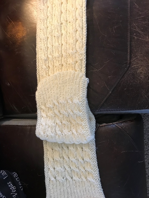 Cream colored reversible cable knitted scarf