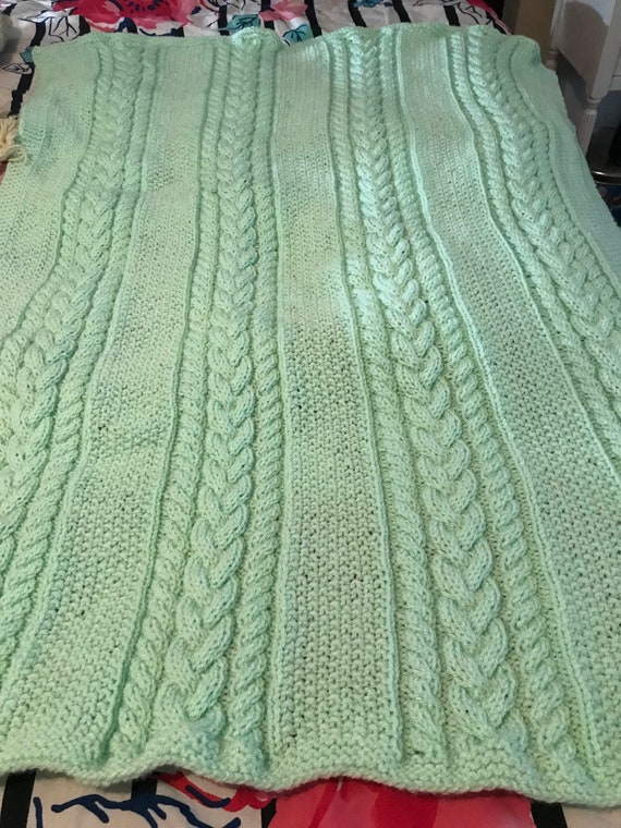 Knitted cable baby blanket in mint green