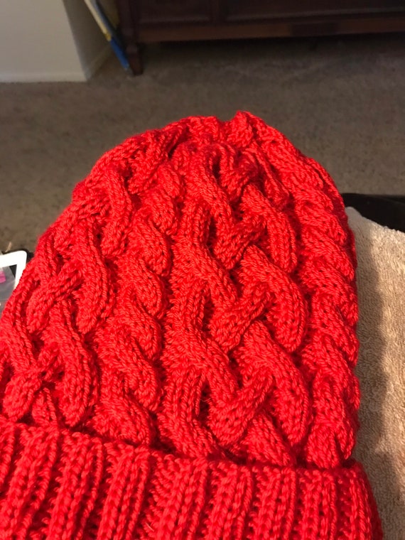 Knitted cable hat in red, white and blue in wool and acrylic blend yarn.