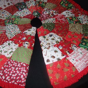K&ouml;nnte beinhalten: Ein runder Weihnachtsbaumrock mit Patchwork-Design. Der Rock zeigt verschiedene festliche Muster in Rot, Gr&uuml;n und Wei&szlig;, darunter Weihnachtsb&auml;ume, Schneem&auml;nner und Zuckerstangen. Ein roter R&uuml;schenrand rundet das Design ab.