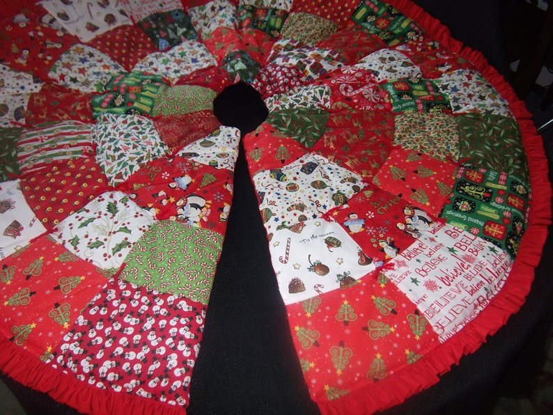 K&ouml;nnte beinhalten: Ein runder Weihnachtsbaumrock mit Patchwork-Design. Der Rock zeigt verschiedene festliche Muster in Rot, Gr&uuml;n und Wei&szlig;, darunter Weihnachtsb&auml;ume, Schneem&auml;nner und Zuckerstangen. Ein roter R&uuml;schenrand rundet das Design ab.