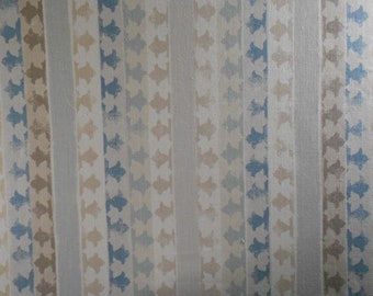 May include: A close-up of a patterned wallpaper with vertical stripes of blue, beige, and white. The pattern is a repeating geometric design.