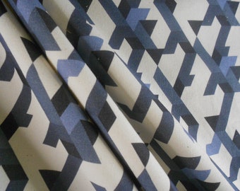 May include: A white fabric with a geometric pattern of black and blue interlocking shapes. The fabric is folded in half, showing the pattern on both sides.