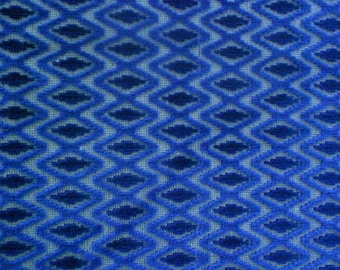 May include: Blue and white patterned fabric with a textured, woven design. The fabric has a geometric pattern of diamonds.