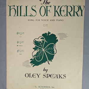 May include: A vintage sheet music cover for the song "The Hills of Kerry" by Oley Speaks. The cover features a green shamrock-shaped outline of Ireland with a green shamrock in the center. The text "50 cents" is printed in the upper right corner.