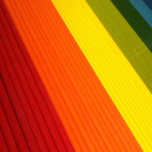 K&ouml;nnte beinhalten: Nahaufnahme eines regenbogenfarbenen gestreiften Stoffes. Der Stoff besteht aus d&uuml;nnen, vertikalen Streifen in Rot, Orange, Gelb, Gr&uuml;n, Blau und Lila.