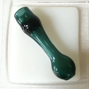 May include: A teal glass pipe with a rounded bowl and a long, slender stem.