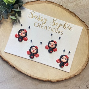 May include: Four black and red ladybug ornaments with white polka dots and black eyes. The ornaments are displayed on a white canvas with the text "Sassy Sophie Creations" in gold glitter lettering.