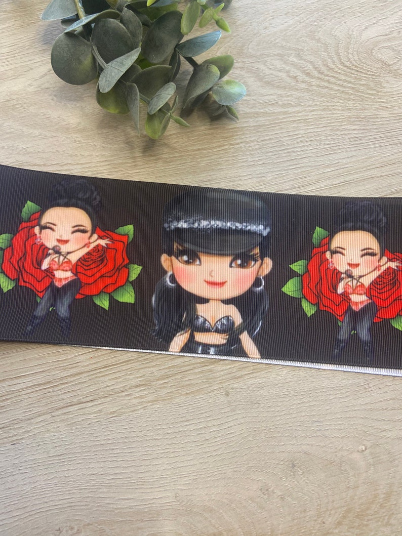 Pu&ograve; includere: Nastro bianco e nero con un motivo ripetuto di tre donne dei cartoni animati che indossano abiti neri e tengono microfoni. Ogni donna &egrave; circondata da rose rosse.