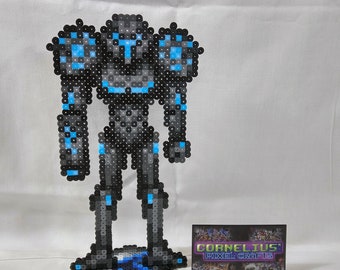 May include: A blue and black pixel art figure of a robot standing on a blue and black pixel art base. The figure is made of small plastic beads. The base has a blue and black pixel art design. The figure is about 25 cm tall.