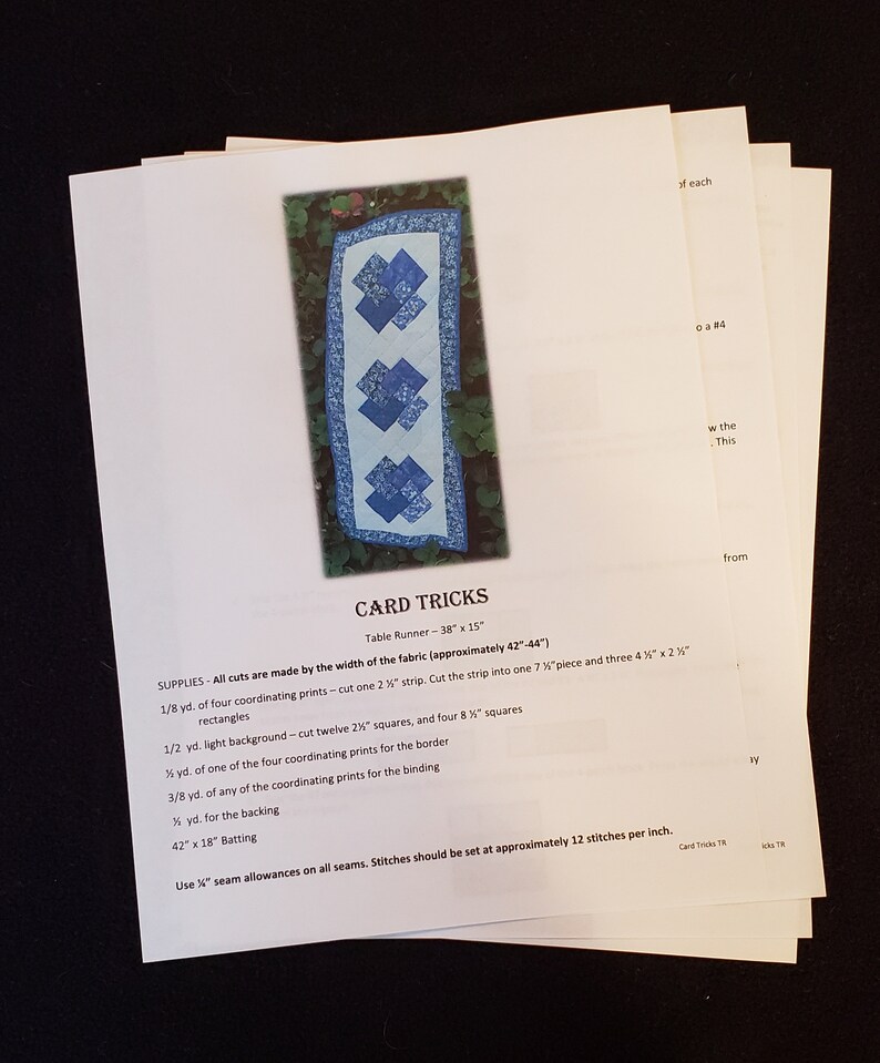 May include: A quilting pattern for a table runner called "Card Tricks". The pattern includes instructions for cutting fabric, sewing seams, and finishing the runner. The runner is 96.5 cm long and 38 cm wide.