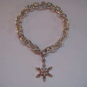 May include: A silver chain bracelet with a snowflake charm.
