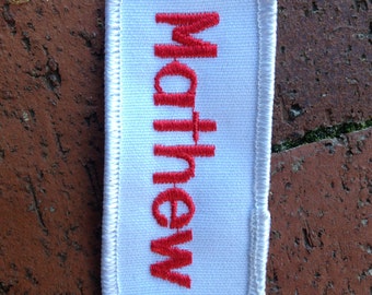 Matt A black work shirt patch that says Matt in white print