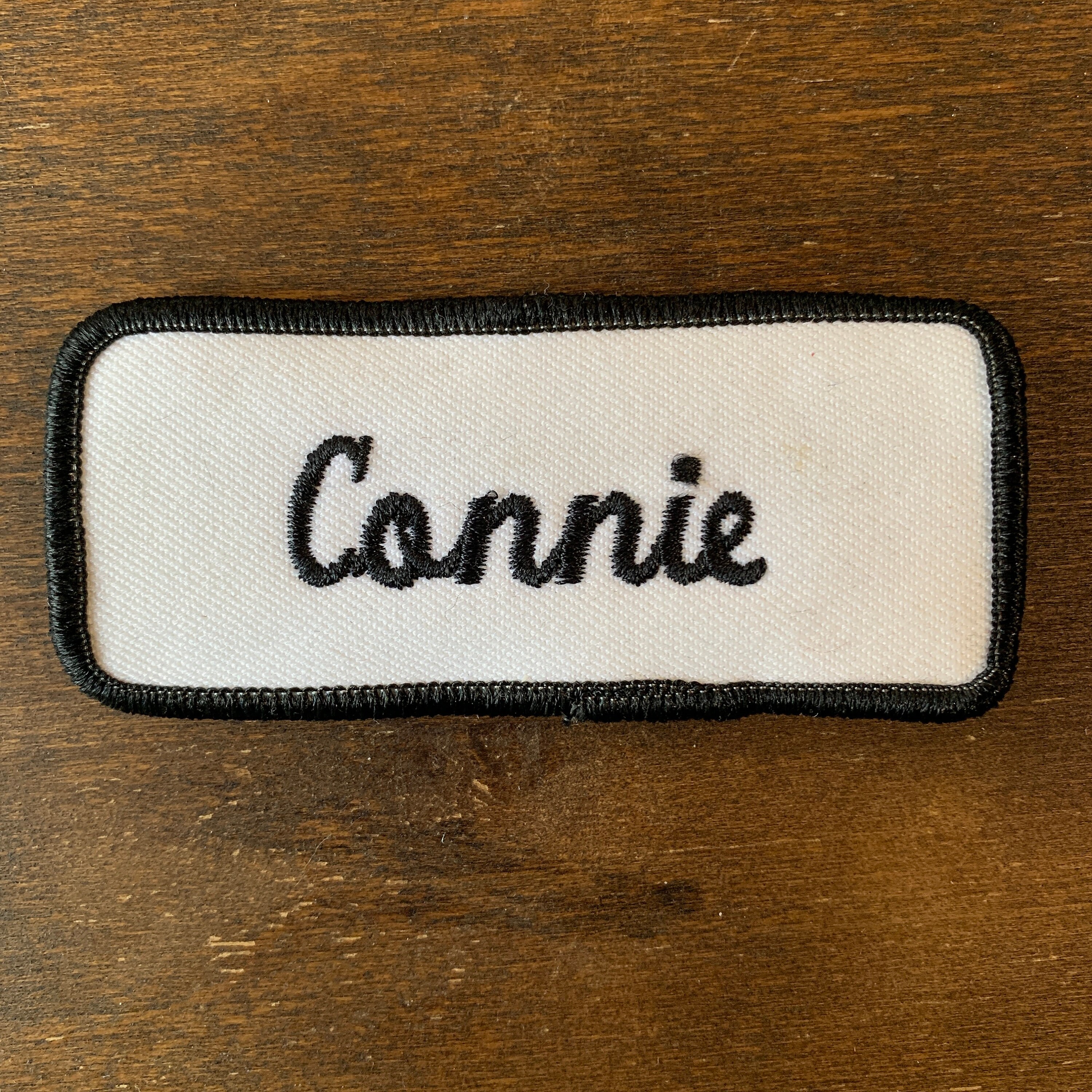 Connie. A white work shirt patch with "Connie" in black script with a black border.