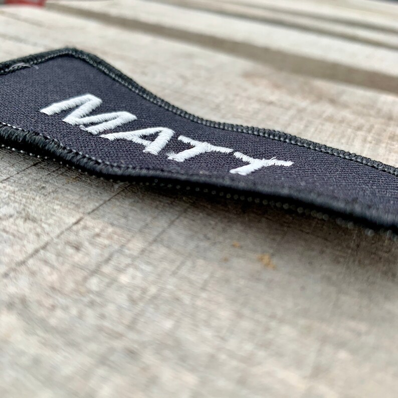 Matt A black work shirt patch that says Matt in white print